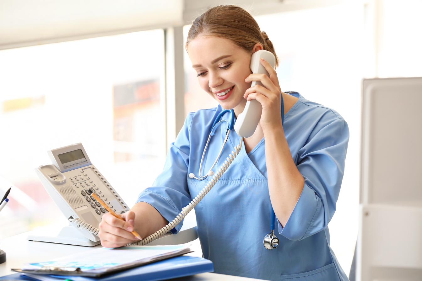 Friendly clinical staff member on the phone with a patient